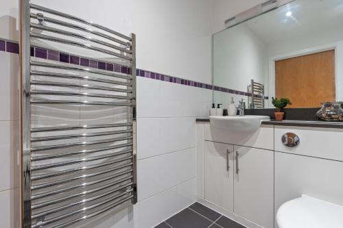 a white bathroom with a sink and a shower at Heart of City Centre Luxury Apartment with Secure Underground Parking in Birmingham
