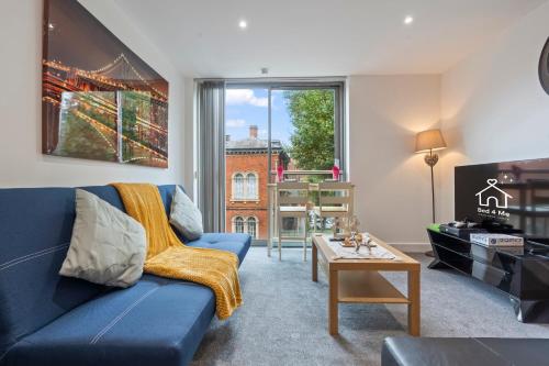 a living room with a blue couch and a window at Heart of City Centre Luxury Apartment with Secure Underground Parking in Birmingham