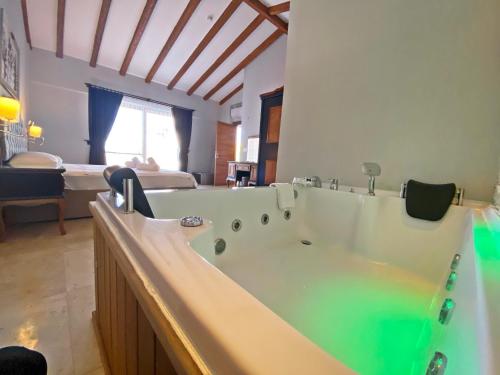 ein Bad mit einer großen Badewanne in einem Zimmer in der Unterkunft Tlos Yalı 3+1 Villa, Özel Havuzlu, Fethiye in Fethiye