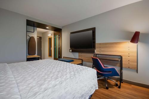 a hotel room with a bed and a flat screen tv at Tru By Hilton Merrillville in Merrillville