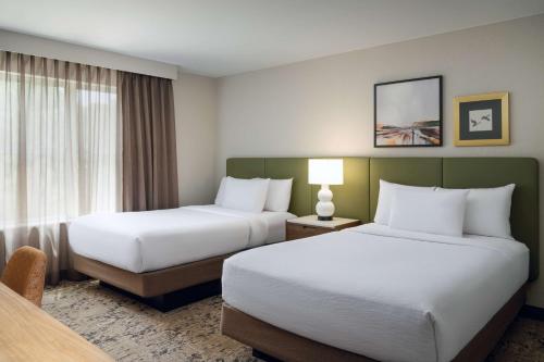 a hotel room with two beds and a window at Embassy Suites by Hilton Memphis East Germantown Area in Memphis
