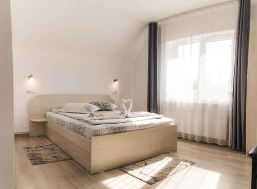 a bedroom with a bed and a large window at Casa Bokor in Sovata
