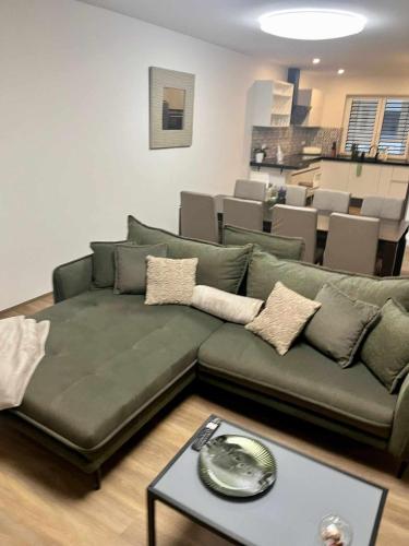 a living room with a green couch and a table at Vila EMMA in Prostějov