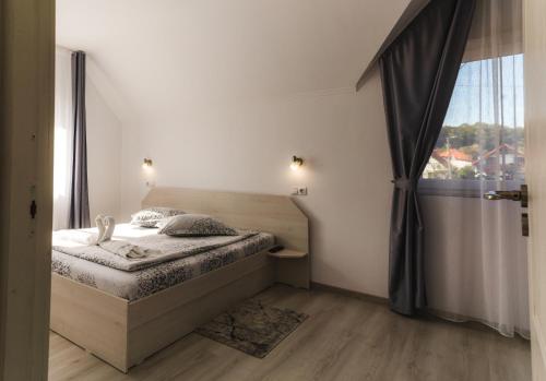 a bedroom with a bed and a large window at Casa Bokor in Sovata