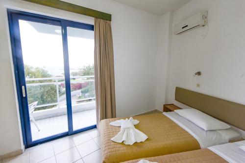a bedroom with a bed with a dress on it at Amalia Sea Hotel in Rhodes Town