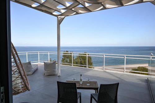 a balcony with a table and chairs and the ocean at Amalia Sea Hotel in Rhodes Town