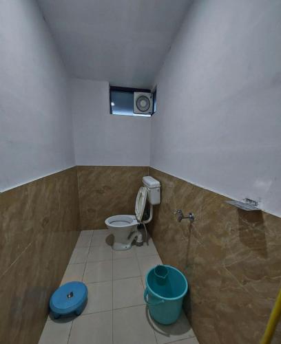 a small bathroom with a toilet and a window at Hostel Hideout in Bhīm Tāl