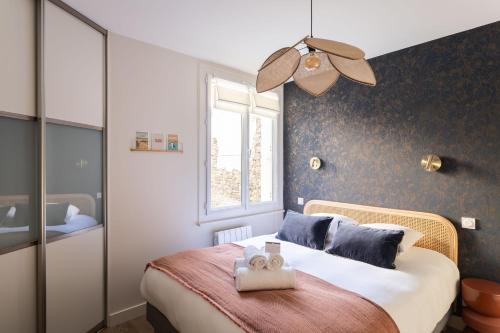 une chambre avec un lit avec deux serviettes dessus dans l'établissement La Citadelle - Appt 4p vue mer, à Saint-Malo