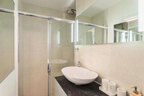 une salle de bain blanche avec un lavabo et une douche dans l'établissement La Citadelle - Appt 4p vue mer, à Saint-Malo