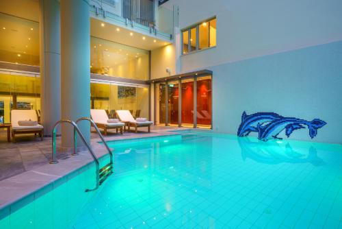 a swimming pool in a building with a swimming pool at Kyma Suites Beach Hotel in Rethymno Town