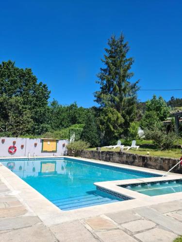a swimming pool with blue water in a yard at Rural Coliving in Pontevedra