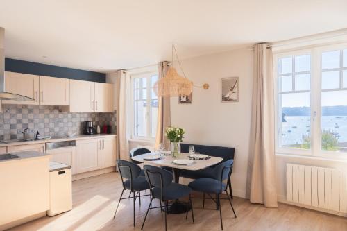 une cuisine et une salle à manger avec une table et des chaises dans l'établissement La Citadelle - Appt 4p vue mer, à Saint-Malo