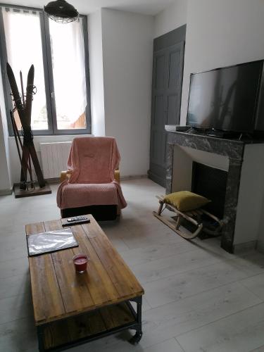 un salon avec une télévision et une cheminée dans l'établissement T3 cosy tout confort, à Luchon