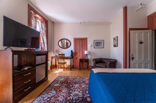 a bedroom with a bed and a flat screen tv at Oneida Community Mansion House in Oneida