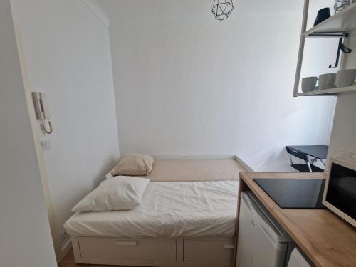 Cette petite chambre comprend un lit et un lavabo. dans l'établissement Studio Niçois Proche Mer, à Nice