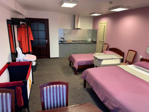 a hotel room with two beds and a kitchen at Baskervilu Muiža in Sērenes