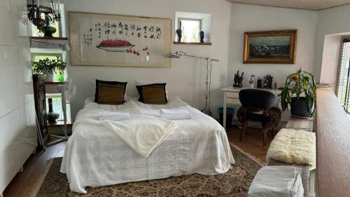 a bedroom with a bed with white sheets and a desk at Unikt boende i egen del av hus nära stad och strand in Ystad