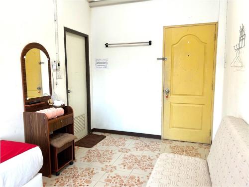 a bedroom with a yellow door and a mirror at Home One Love Ayutthaya GH in Phra Nakhon Si Ayutthaya