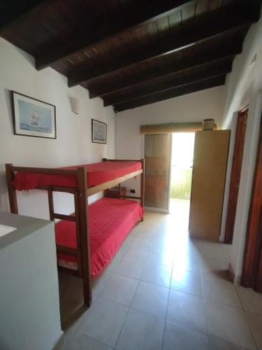 ein Schlafzimmer mit einem Bett mit einer roten Tagesdecke in der Unterkunft Maraja in Mar de Ajó