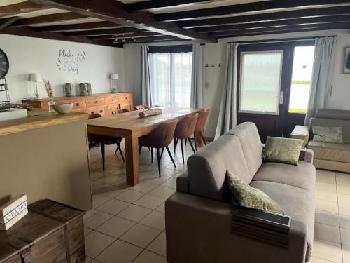 a kitchen and living room with a couch and a table at chaletje tis-ier-goed in Jabbeke
