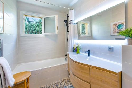 La salle de bains est pourvue d'une baignoire blanche, d'un lavabo et d'une baignoire. dans l'établissement Villa Tourtour by Villa Plus, à Tourtour