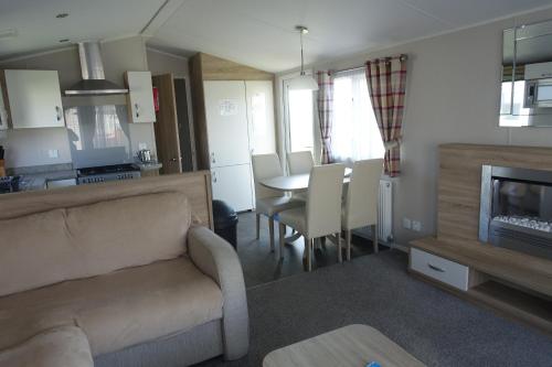 a living room with a couch and a dining room table at Red Lion Holiday Park in Arbroath
