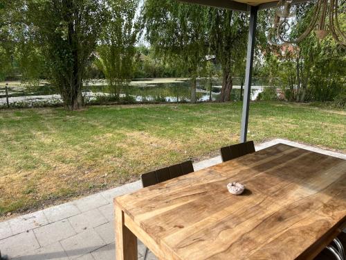a wooden table with two chairs and an umbrella at chaletje tis-ier-goed in Jabbeke