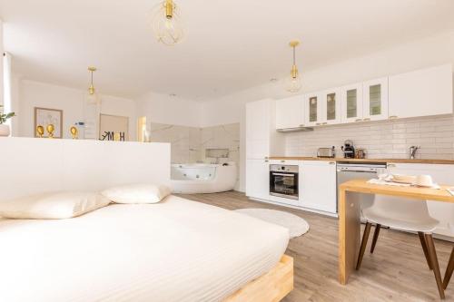 - une cuisine blanche avec un lit et une table dans l'établissement Le doux refuge, à Dallet