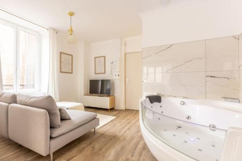 a white living room with a tub and a couch at Le doux refuge in Dallet