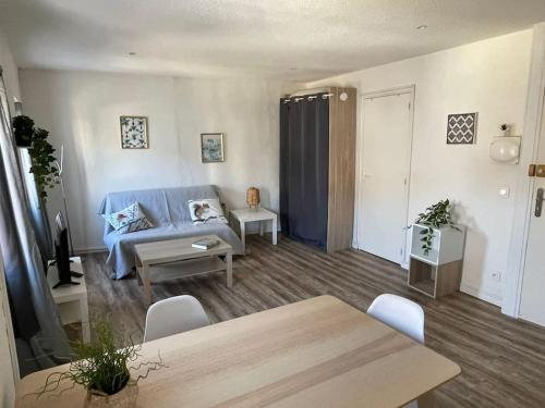 un salon avec un canapé bleu et une table dans l'établissement Grand Studio à 100m des plages, à Toulon