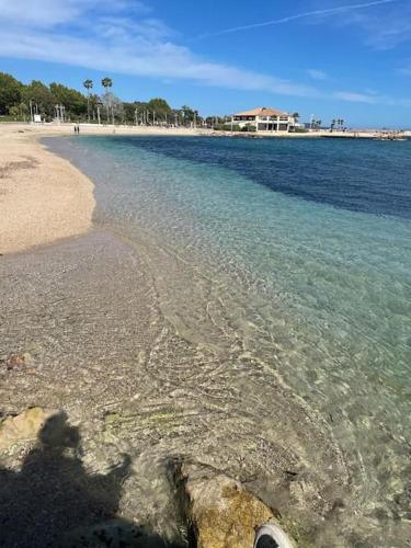 - une vue sur la plage avec une maison en arrière-plan dans l'établissement Grand Studio à 100m des plages, à Toulon
