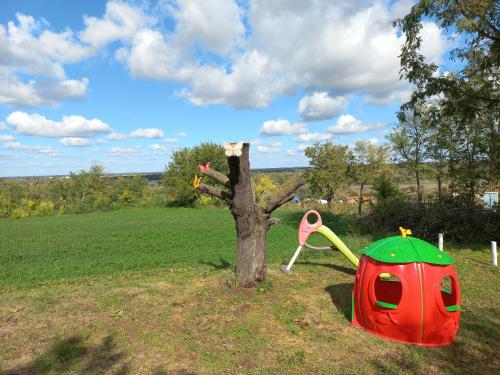 a tree with a red and green tent next to a tree at Honey hill apartment Fruska Gora in Čerević