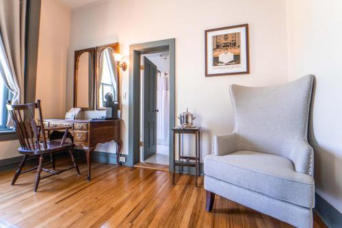 a living room with a chair and a desk at Oneida Community Mansion House in Oneida