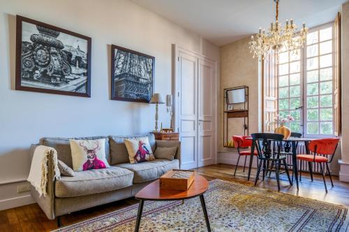 un salon avec un canapé et une table dans l'établissement Appartement raffiné vue cathédrale, jardin, wifi, à Tours