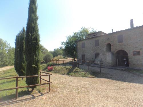 a building with a fence and a tree next to it at Podere Gnocchi in Rapale