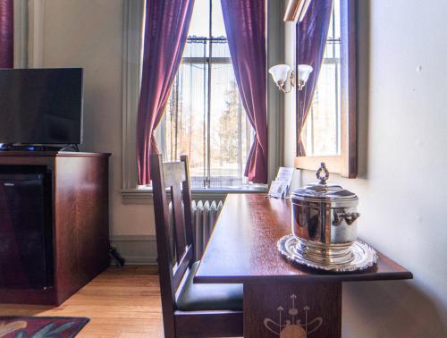 a dining room with a table and a television at Oneida Community Mansion House in Oneida