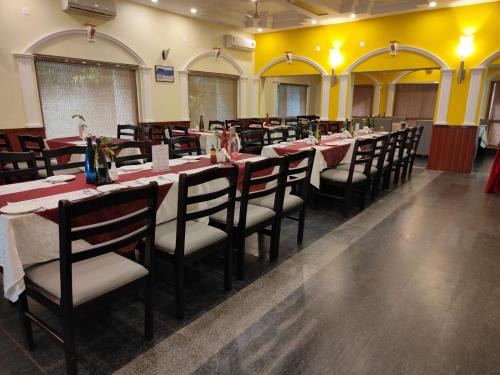 a row of tables and chairs in a restaurant at Hotel Badami Court in Badami