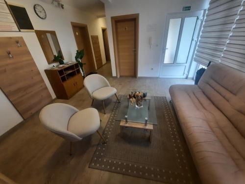 a living room with a couch and two chairs and a table at APARTMAN Stil in Virovitica
