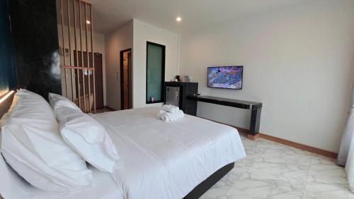 a bedroom with a large white bed with white pillows at One Sakon Nakhon Hotel in Ban Na Weng