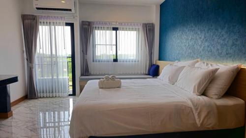 a large white bed with a stuffed animal on top of it at One Sakon Nakhon Hotel in Ban Na Weng