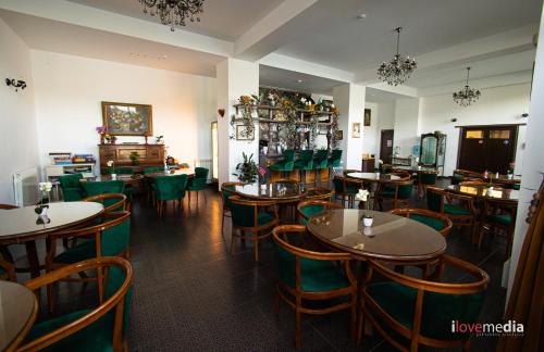 a dining room with tables and green chairs at Riviera 990 - Resort & Restaurant in Eşelniţa
