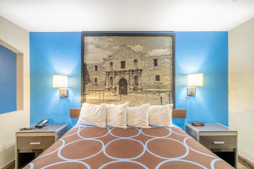 a bedroom with a bed with a painting on the wall at Super 8 by Wyndham San Antonio/Riverwalk Area in San Antonio