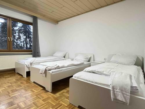 a room with three beds and a window at SAD501 - Gemütliche Monteurwohnung in Schwandorf in Bayern