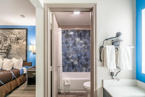 a bathroom with a toilet and a bath tub at Super 8 by Wyndham San Antonio/Riverwalk Area in San Antonio