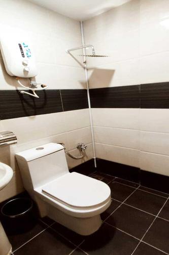 a bathroom with a white toilet and a sink at ABA Hotel Sarawak in Kota Samarahan