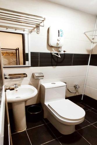 a bathroom with a toilet and a sink at ABA Hotel Sarawak in Kota Samarahan