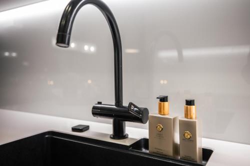 a kitchen sink with two candles and a faucet at Santa's Luxury City Apartment 1 in Rovaniemi