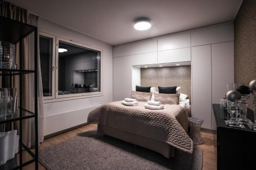 a bedroom with a bed with two towels on it at Santa's Luxury City Apartment 1 in Rovaniemi