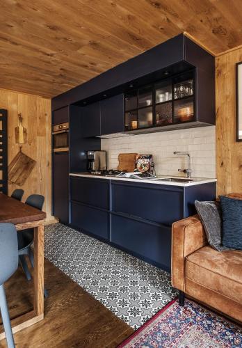 a kitchen with blue cabinets and a couch and a table at Bosuil in Retie