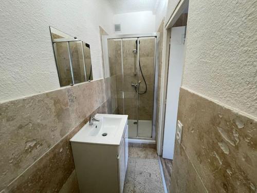 une salle de bain avec un lavabo et une douche dans l'établissement Beau Studio à 100m des plages, à Toulon